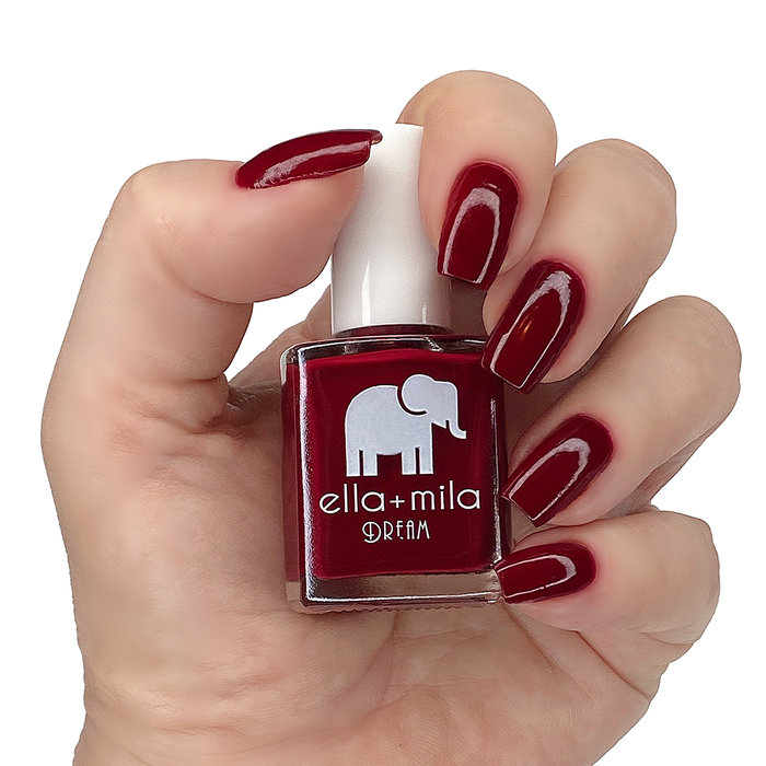 Wicked Red burgundy red nail polish manicure on a light skin tone with the bottle
